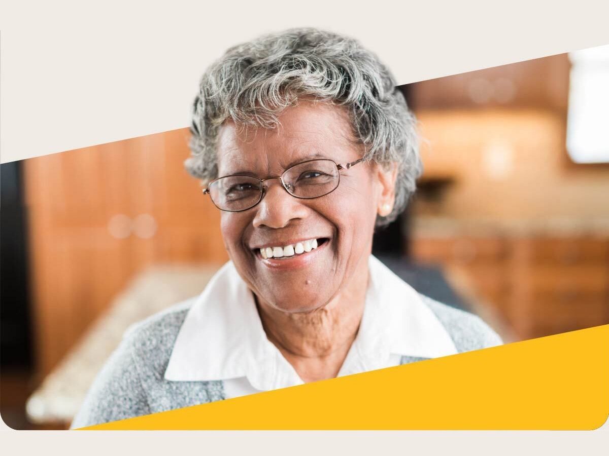 Neatly dressed elderly woman smiling at home